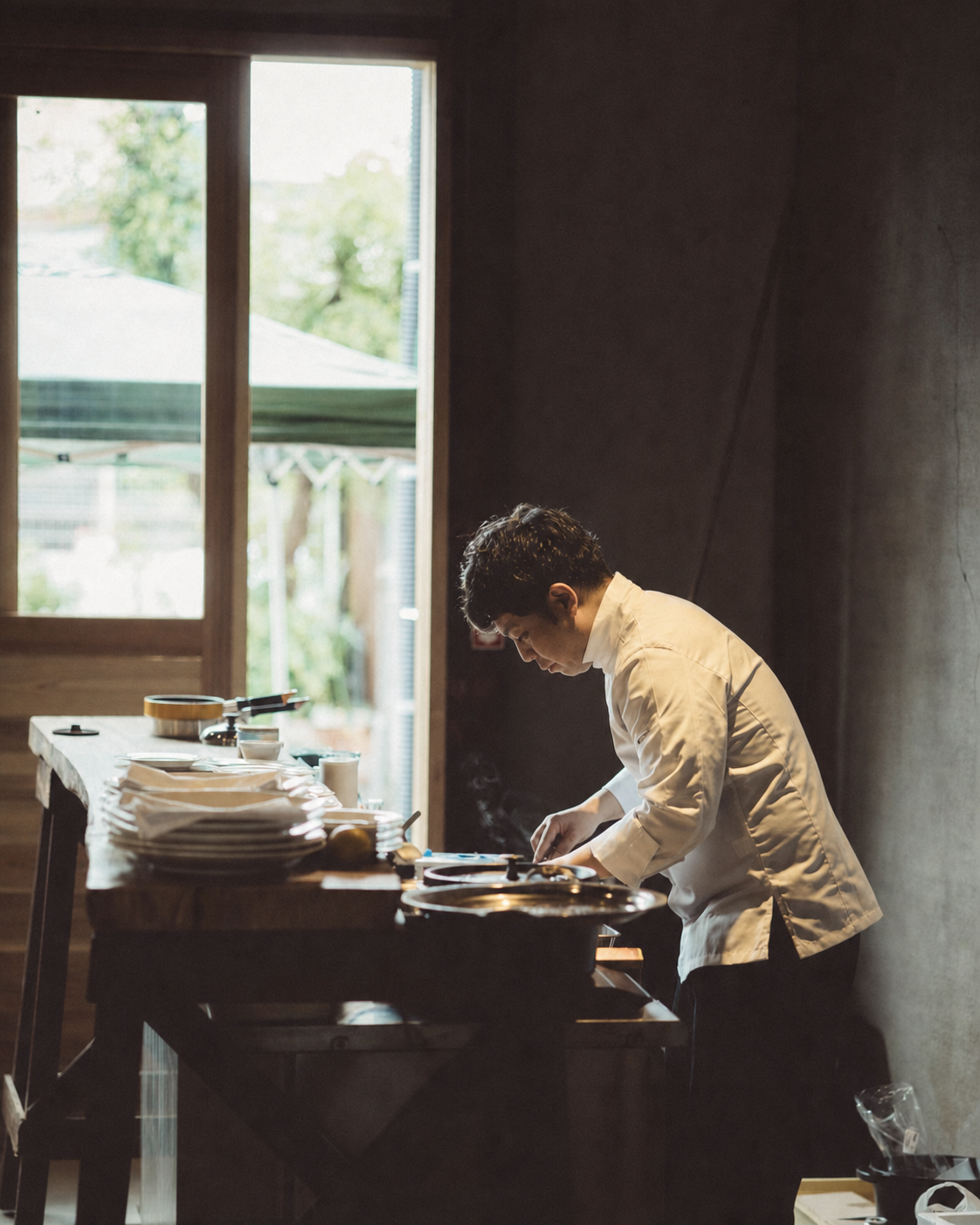 月と小屋の厨房で料理を仕上げるシェフ